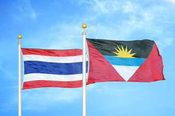 Thailand and Antigua and Barbuda two flags on flagpoles and blue sky