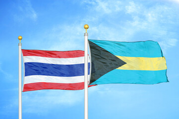 Thailand and Bahamas two flags on flagpoles and blue sky