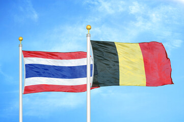 Thailand and Belgium two flags on flagpoles and blue sky