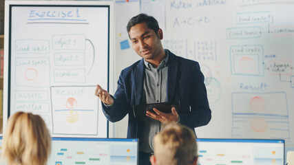 Elementary School Class: Teacher Uses Interactive Digital Whiteboard, Explains Lesson to Diverse Group of Smart Children. Kids getting Modern Education, Learn Computer Science, Software Programming