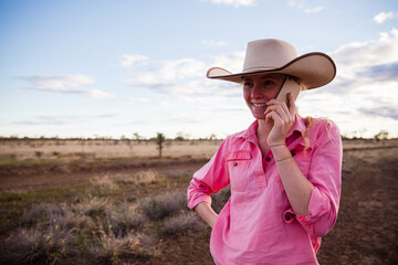 Young female farmer talking on smart phone