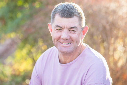 Man in 50s in garden smiling with dimples
