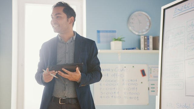 School Class: Portrait of the Enthusiastic and Motivated Teacher Using Digital Whiteboard and Tablet, Explains Lesson to Smart Children. Students getting Modern Education. Only Teacher