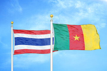 Thailand and Cameroon two flags on flagpoles and blue sky