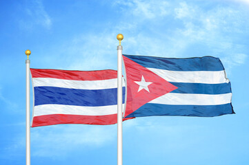 Thailand and Cuba two flags on flagpoles and blue sky