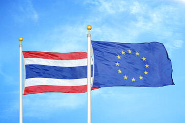 Thailand and European Union two flags on flagpoles and blue sky