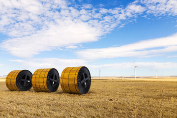Rolls of cables with wind towers in the background