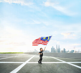Fototapeta premium Happy boy running while holding Malaysia flag with cityscape.