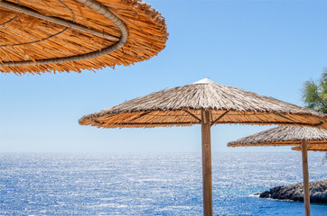Straw beach umbrellas and sunbeds on the west coast of Zakynthos island in Greece