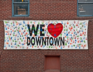 This sign with handprints all over says We Love Downtown with a heart for the word love.  It's set...
