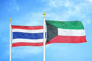 Thailand and Kuwait two flags on flagpoles and blue sky