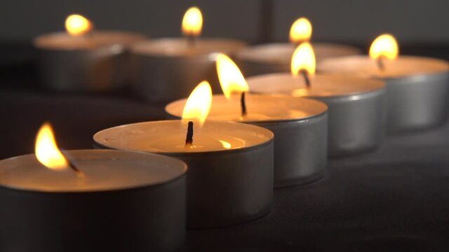 Row of tealights being blown off, slow motion