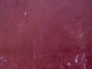 burgundy concrete wall with cracks and stains