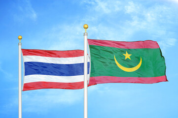 Thailand and Mauritania two flags on flagpoles and blue sky