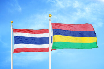Thailand and Mauritius two flags on flagpoles and blue sky