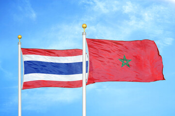 Thailand and Morocco two flags on flagpoles and blue sky