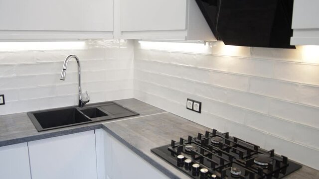 White compact kitchen interior with built-in household appliances