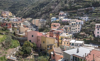 Fototapeta premium Riomaggiore village, first & most southern of Cinque Terre coastal villages, located in a small & narrow uphill valley, as seen from north to south, La Spezia, Liguria region, Italy.