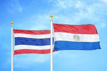 Thailand and Paraguay two flags on flagpoles and blue sky