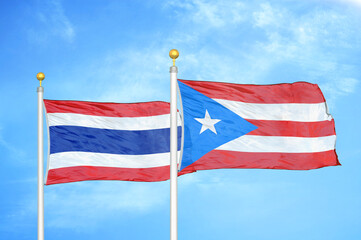 Thailand and Puerto Rico two flags on flagpoles and blue sky