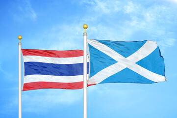 Thailand and Scotland two flags on flagpoles and blue sky