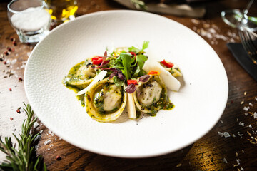 Black Angus hand-made dumplings. Cucumber-julienne with chilli-garlic butter or beef stock with sour cream. Delicious meat food closeup served on a table for lunch in modern cuisine gourmet restaurant