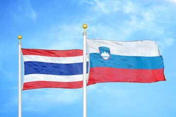 Thailand and Slovenia two flags on flagpoles and blue sky