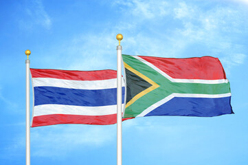 Thailand and South Africa two flags on flagpoles and blue sky