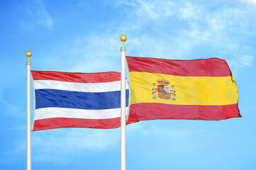 Thailand and Spain two flags on flagpoles and blue sky