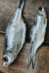 Two dried fish on a wooden background 