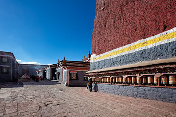 A Tibetan pilgrim turns prayer wheels at Sakya monastery, Tibet.