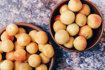 Lots of ripe yellow apricots close up in a crockery on the table