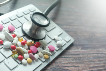 Close up of pills and stethoscope on keyboard 