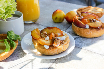 al fresco Breakfast of grilled bread rolls with goat fat, fruit, nuts, orange juice and coffee