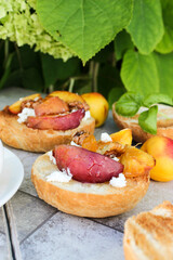 al fresco Breakfast of grilled bread rolls with goat fat, fruit, nuts, orange juice and coffee