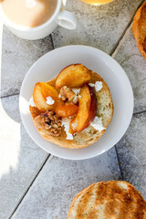 al fresco Breakfast of grilled bread rolls with goat fat, fruit, nuts, orange juice and coffee