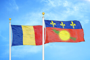 Romania and Guadeloupe two flags on flagpoles and blue sky