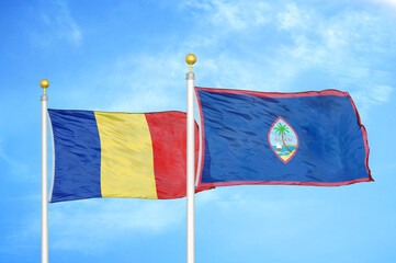 Romania and Guam two flags on flagpoles and blue sky