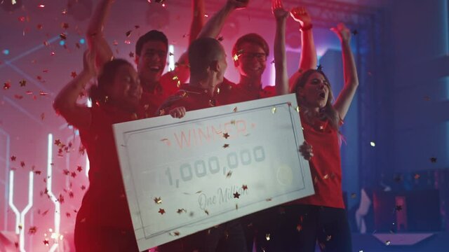 Diverse Gamers Esport Team Winner of the Video Games Tournament Celebrates Victory Cheering and Lifting $1,000,000 Prize Money Presentation Check. Championship Arena Online Streaming of Cyber Games 