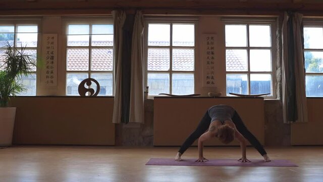 Calm woman doing yoga in Wide Legged Forward Bend pose