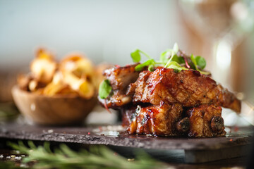 Pork ribs cooked at low temperature. Blackcurrant sauce, parsnip chips with Parmesan cheese. Delicious healthy meat food closeup served on a table for lunch in modern cuisine gourmet restaurant