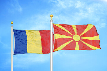 Romania and North Macedonia two flags on flagpoles and blue sky