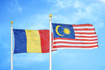 Romania and Malaysia two flags on flagpoles and blue sky