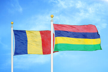 Romania and Mauritius two flags on flagpoles and blue sky