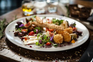 Cheese platter for two: Goat cheese cream, gorgonzola, camembert, grissini and fig jam. Delicious healthy Italian traditional food closeup served for lunch in modern gourmet cuisine restaurant