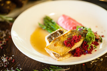 Pike-perch fillet. Asparagus, pearl couscous, white wine sauce, beet-flavored mashed potatoes. Delicious seafood fish closeup served on a table for lunch in modern cuisine gourmet restaurant