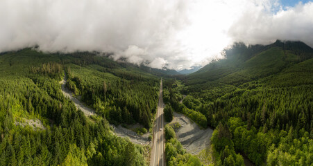 Aerial panoramic View of a scenic Highway surrounded by Canadian Mountain Landscape during a summer morning. Taken in Northern Vancouver Island, British Columbia, Canada.