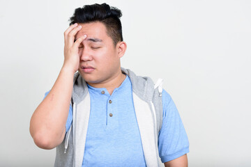 Fototapeta premium Portrait of stressed young overweight Asian man getting bad news