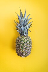 Raw pineapple on yellow background