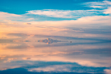 Fototapeta na wymiar Stunning snow-capped mountain landscape reflected in the water with sunset light at the impressive Salar de Uyuni, Bolivia, Sur Anerica.